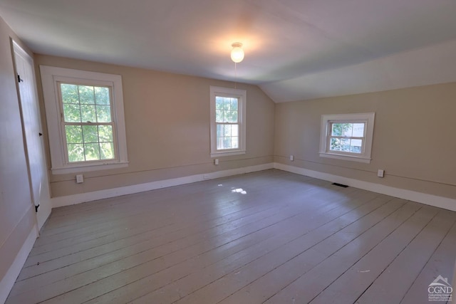 additional living space featuring lofted ceiling and light wood-type flooring