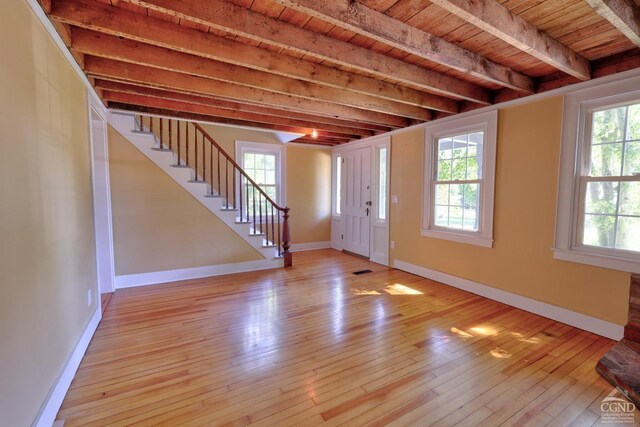 foyer with beam ceiling, plenty of natural light, and wooden ceiling