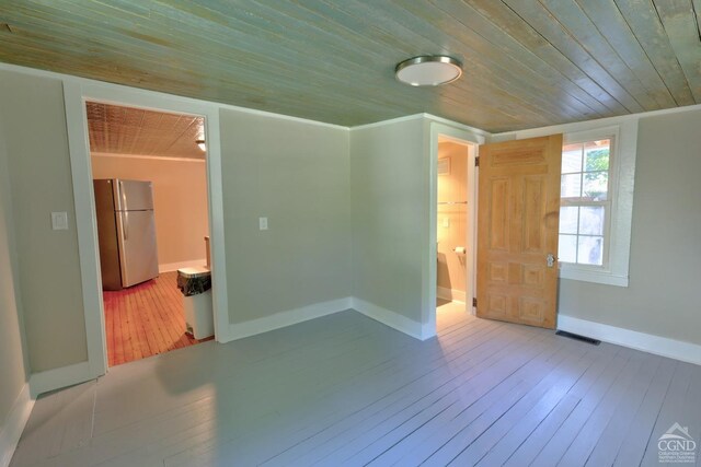 empty room featuring ornamental molding, light hardwood / wood-style flooring, and wooden ceiling