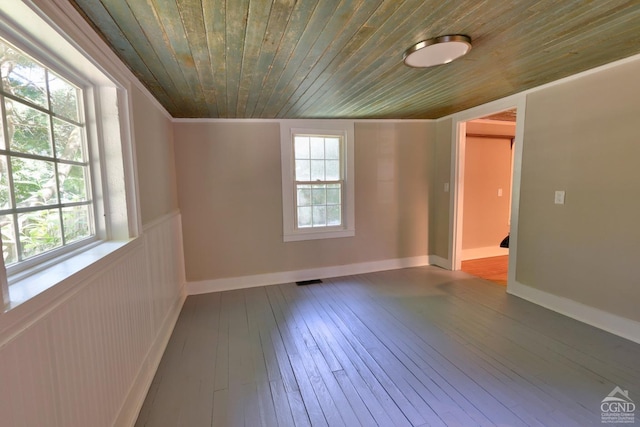 spare room with hardwood / wood-style floors, wooden ceiling, ornamental molding, and a healthy amount of sunlight