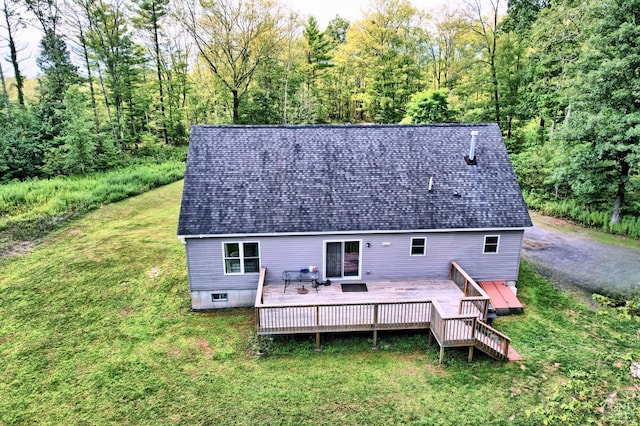 back of house featuring a lawn and a wooden deck