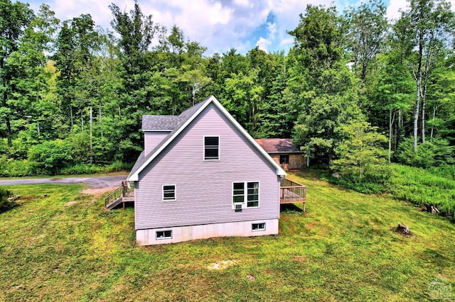 view of side of property featuring a wooden deck and a lawn