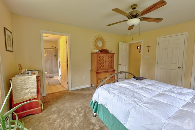 carpeted bedroom with ensuite bath and ceiling fan