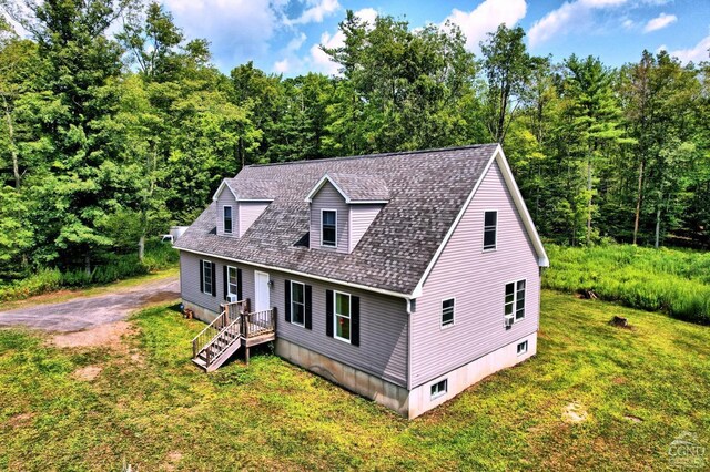 cape cod house featuring a front yard