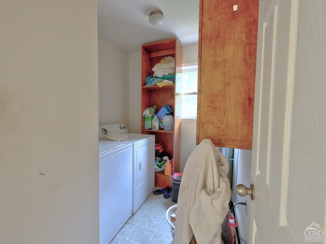 clothes washing area featuring light tile patterned floors and washing machine and clothes dryer