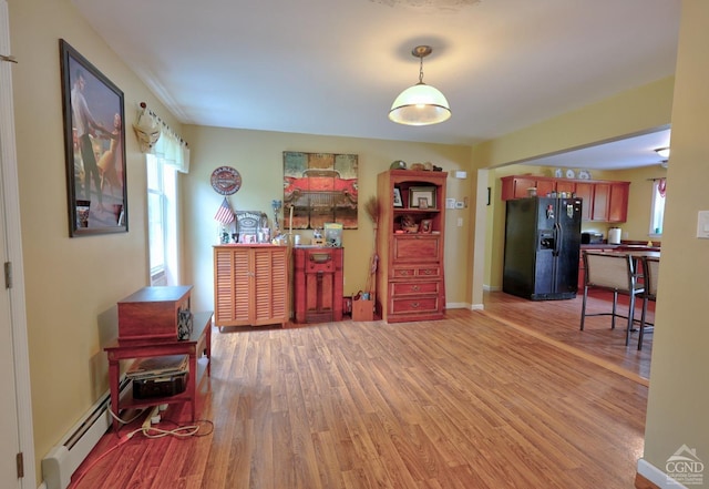 interior space with wood-type flooring and a baseboard heating unit