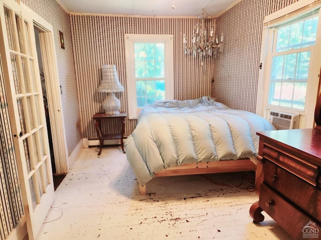 bedroom with a notable chandelier, cooling unit, baseboard heating, and multiple windows