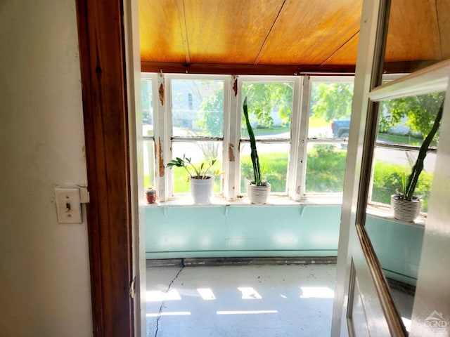 unfurnished sunroom featuring a healthy amount of sunlight and wood ceiling