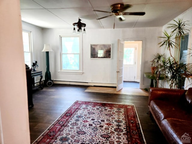 living room with dark hardwood / wood-style floors, ceiling fan, and baseboard heating