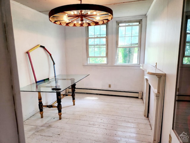 unfurnished dining area featuring a chandelier, light hardwood / wood-style floors, and baseboard heating