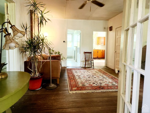 sitting room featuring dark hardwood / wood-style flooring, a baseboard radiator, and ceiling fan