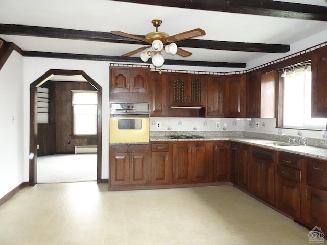 kitchen with sink, ceiling fan, beamed ceiling, wall oven, and gas cooktop