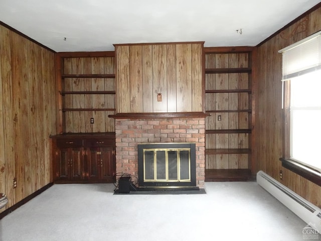 unfurnished living room featuring a baseboard radiator, a healthy amount of sunlight, and wood walls