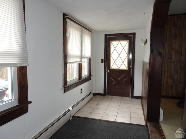 foyer featuring plenty of natural light, light tile patterned floors, and a baseboard heating unit