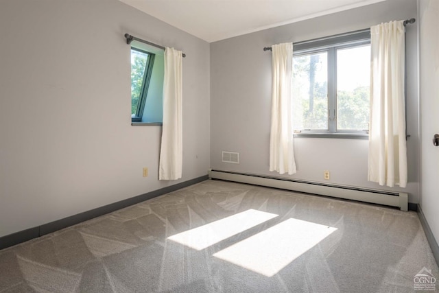 carpeted empty room featuring baseboard heating and plenty of natural light