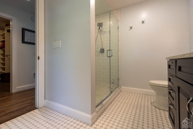 bathroom with toilet, vanity, and walk in shower