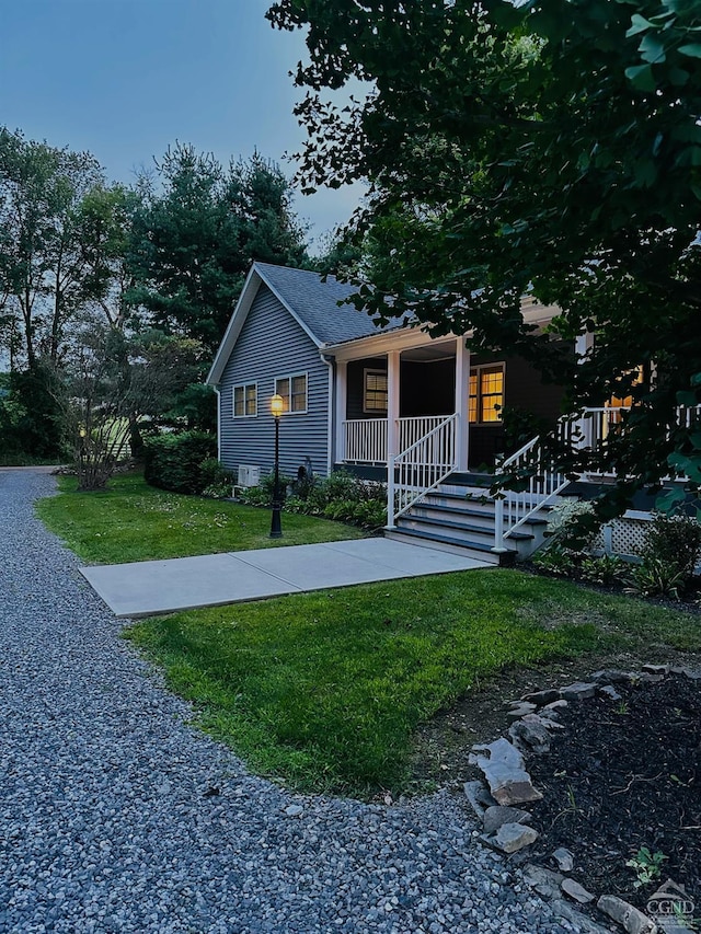 view of front of home with covered porch and a front lawn