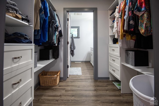 walk in closet with dark wood-type flooring