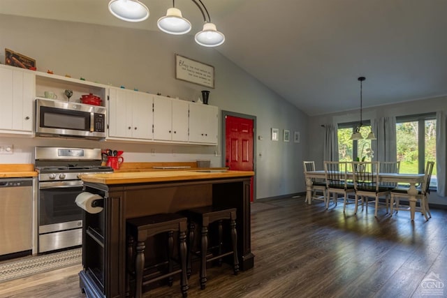 kitchen with dark hardwood / wood-style floors, white cabinets, stainless steel appliances, and pendant lighting