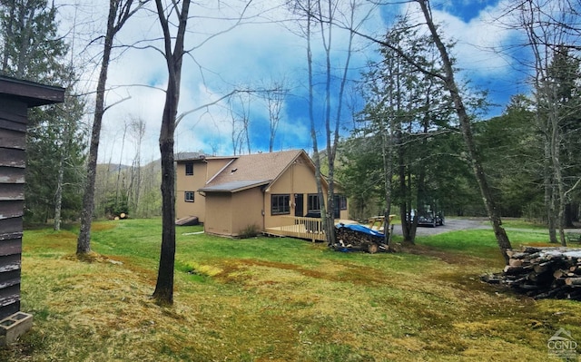 back of property featuring a yard and stucco siding