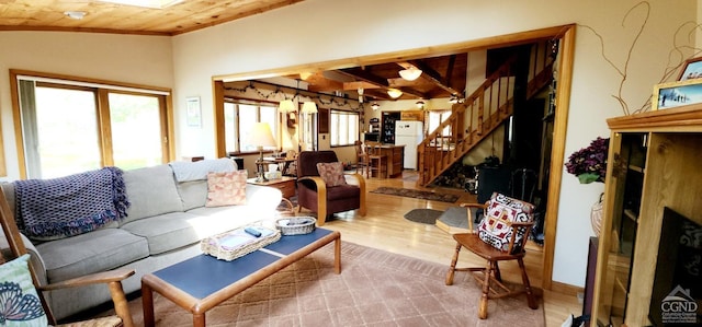 living room featuring wood finished floors, stairway, wooden ceiling, lofted ceiling, and ornamental molding