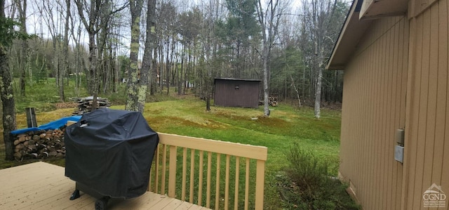 deck featuring a lawn, a storage unit, an outdoor structure, and area for grilling