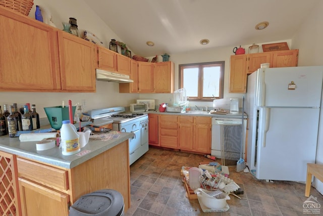 kitchen featuring light brown cabinetry, white appliances, lofted ceiling, and sink