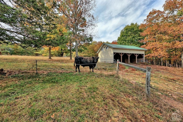 view of yard featuring a rural view and an outbuilding