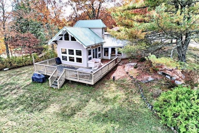 rear view of property with a lawn, a wooden deck, and a sunroom