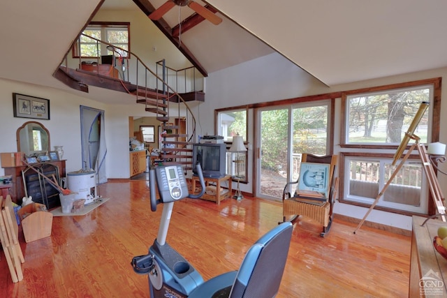 exercise room featuring hardwood / wood-style flooring, ceiling fan, and high vaulted ceiling