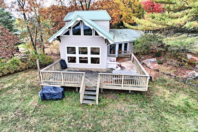 rear view of property with a wooden deck and a yard