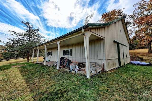 view of side of home with a lawn and an outbuilding