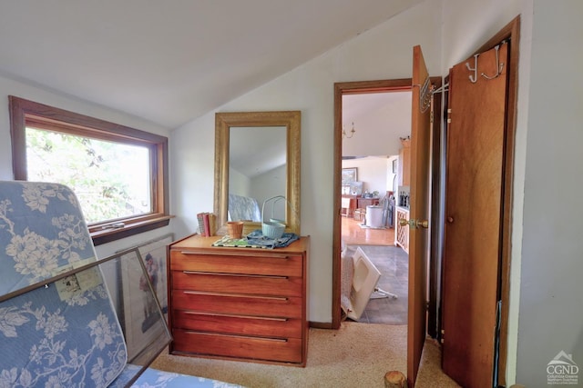 hallway with light colored carpet and lofted ceiling