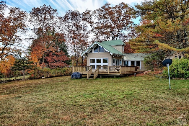 rear view of property featuring a lawn and a wooden deck