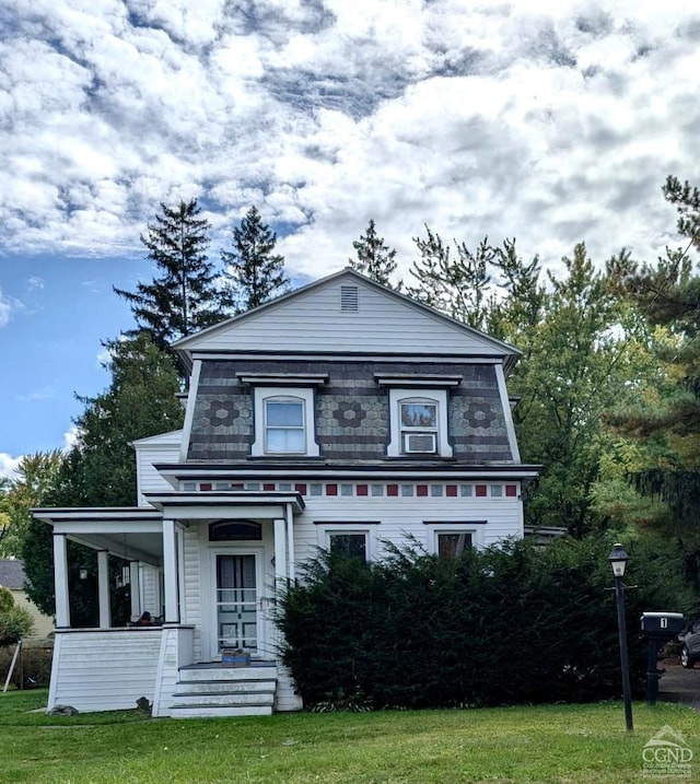 view of front facade featuring covered porch and a front lawn