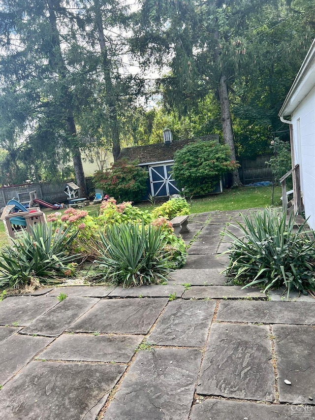 view of yard featuring a storage shed and a patio area