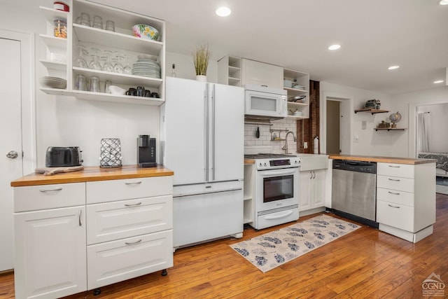 kitchen featuring white appliances, white cabinetry, tasteful backsplash, light hardwood / wood-style floors, and butcher block counters