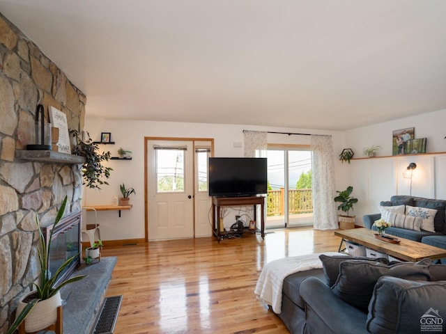 living room with light hardwood / wood-style floors and a fireplace