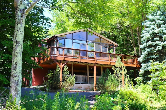 rear view of house with a sunroom and a deck