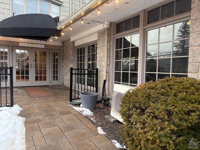 view of exterior entry featuring french doors and ac unit