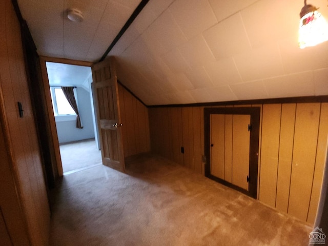 bonus room with vaulted ceiling, wooden walls, and carpet floors