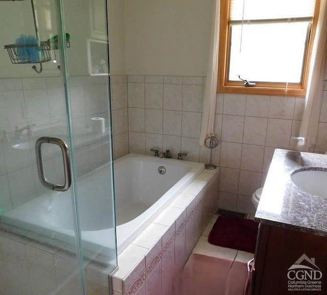 full bathroom with vanity, toilet, independent shower and bath, and tile walls