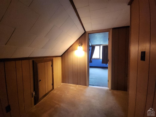 bonus room with vaulted ceiling, carpet flooring, and wooden walls