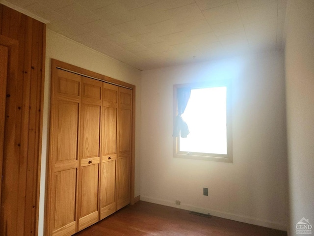 unfurnished bedroom with wood-type flooring and a closet