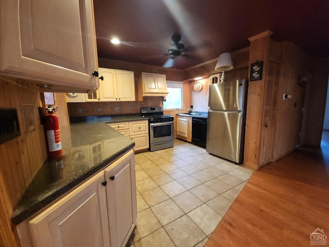 kitchen featuring ceiling fan, stainless steel appliances, dark stone counters, and light tile patterned floors