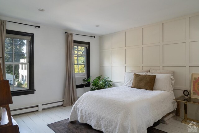 bedroom with baseboard heating and light wood-type flooring