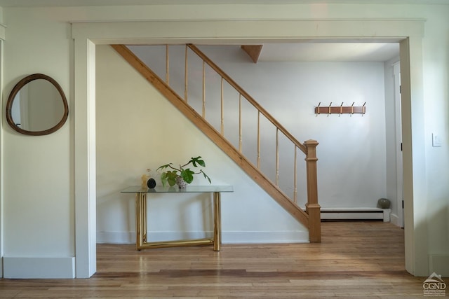 staircase featuring hardwood / wood-style floors and baseboard heating