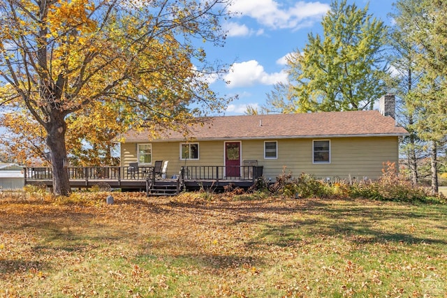 rear view of property with a lawn and a deck