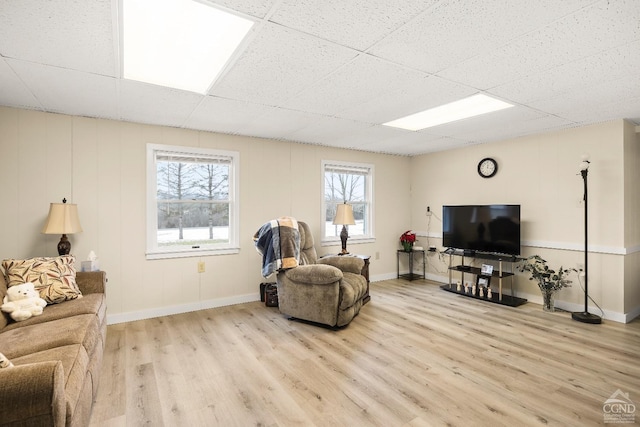 living room with a drop ceiling and light hardwood / wood-style floors