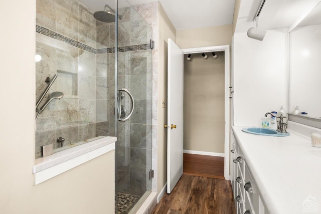 bathroom featuring hardwood / wood-style flooring, vanity, and walk in shower